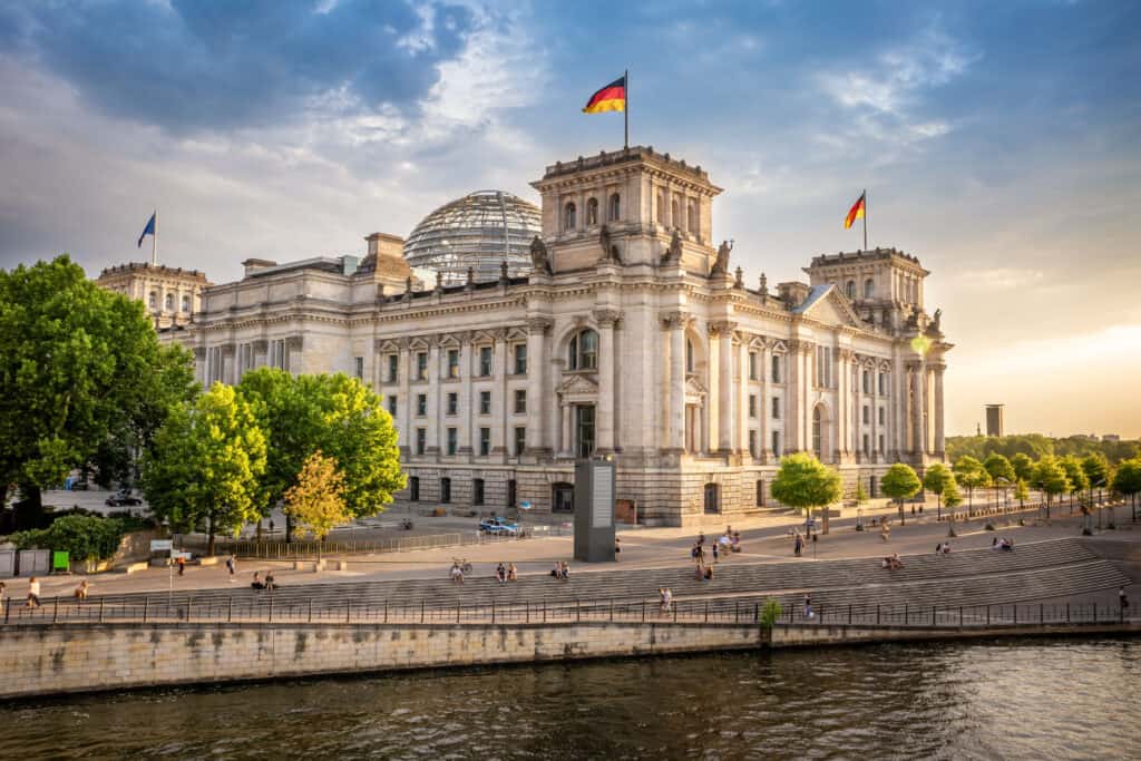 Reichstag building in Berlin, German parliament with a glass dome, view from river during sunset.
