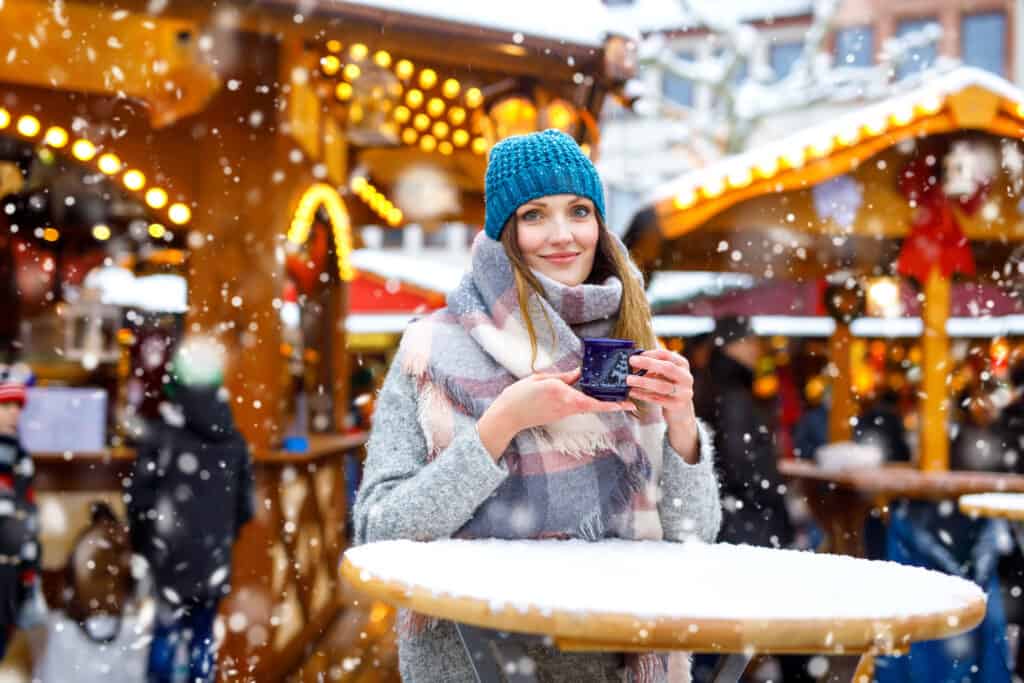 Woman drinking hot mulled wine at a German Christmas market.