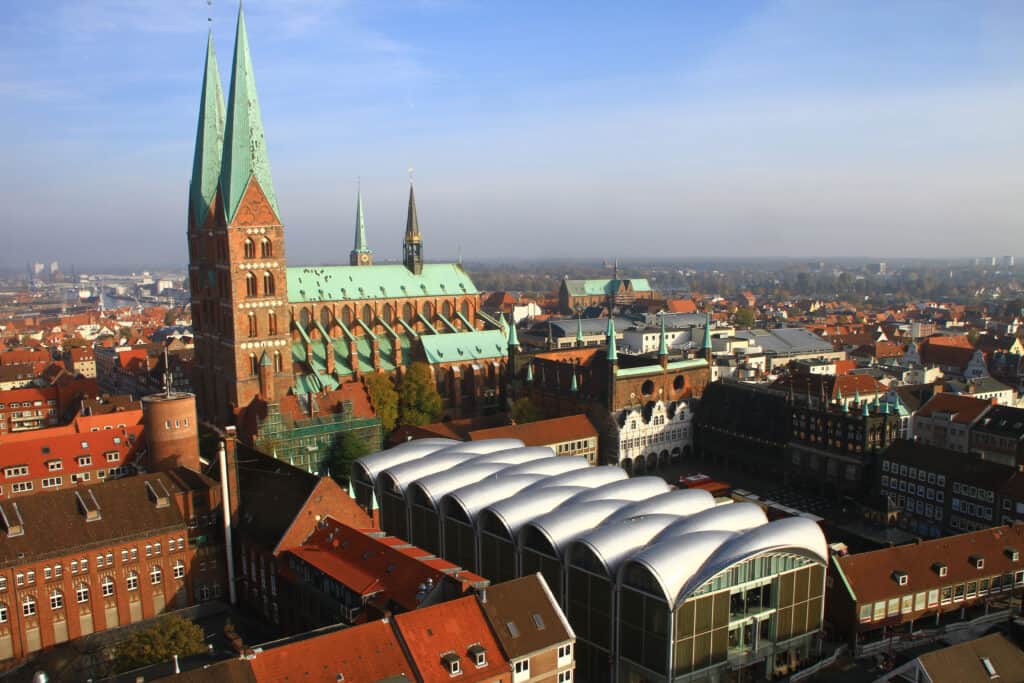 Aerial view of Lübeck Old Town with gabled houses, town hall, and St. Mary's Church in autumn.