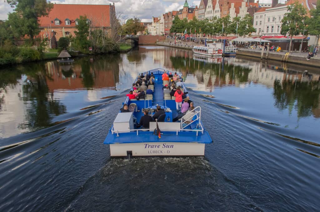 Pleasure boat with tourists sailing on a river in Lübeck, Germany