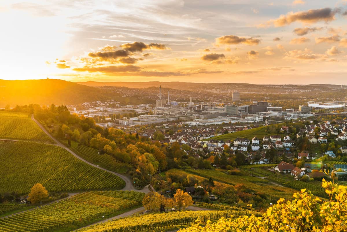 Aerial view of Stuttgart during sunset, cityscape bathed in golden hues.
