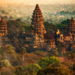 Aerial view of Angkor Wat Temple surrounded by lush greenery in Siem Reap, Cambodia, showcasing its vast scale and layout