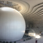 Visitors lounging and reading in the unique spherical auditorium of Binhai Library.