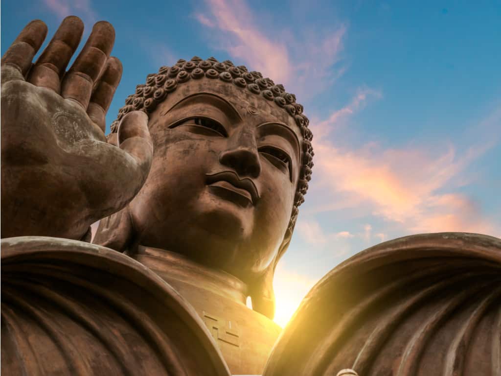 A close-up of the Tian Tan Buddha's face, exuding calmness and wisdom against a backdrop of clear blue skies.