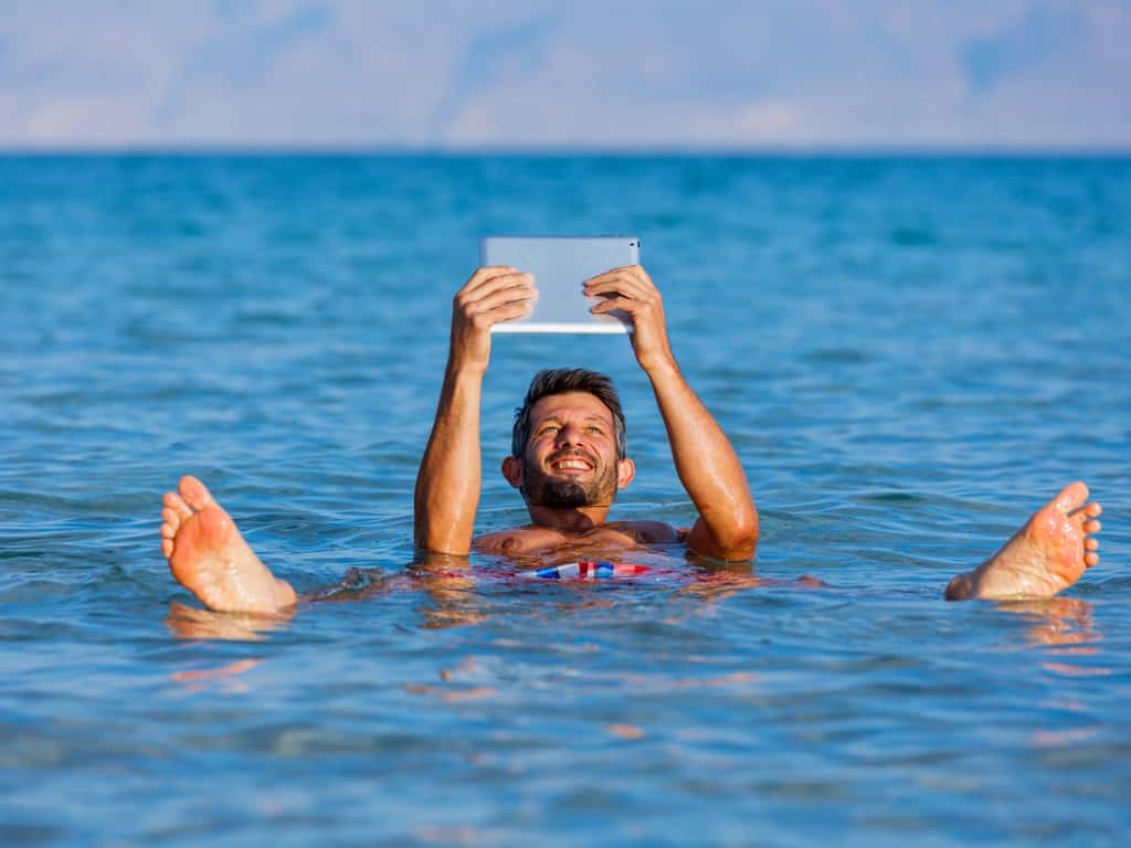 Visitors floating effortlessly in the Dead Sea's salty waters, enjoying the natural buoyancy.