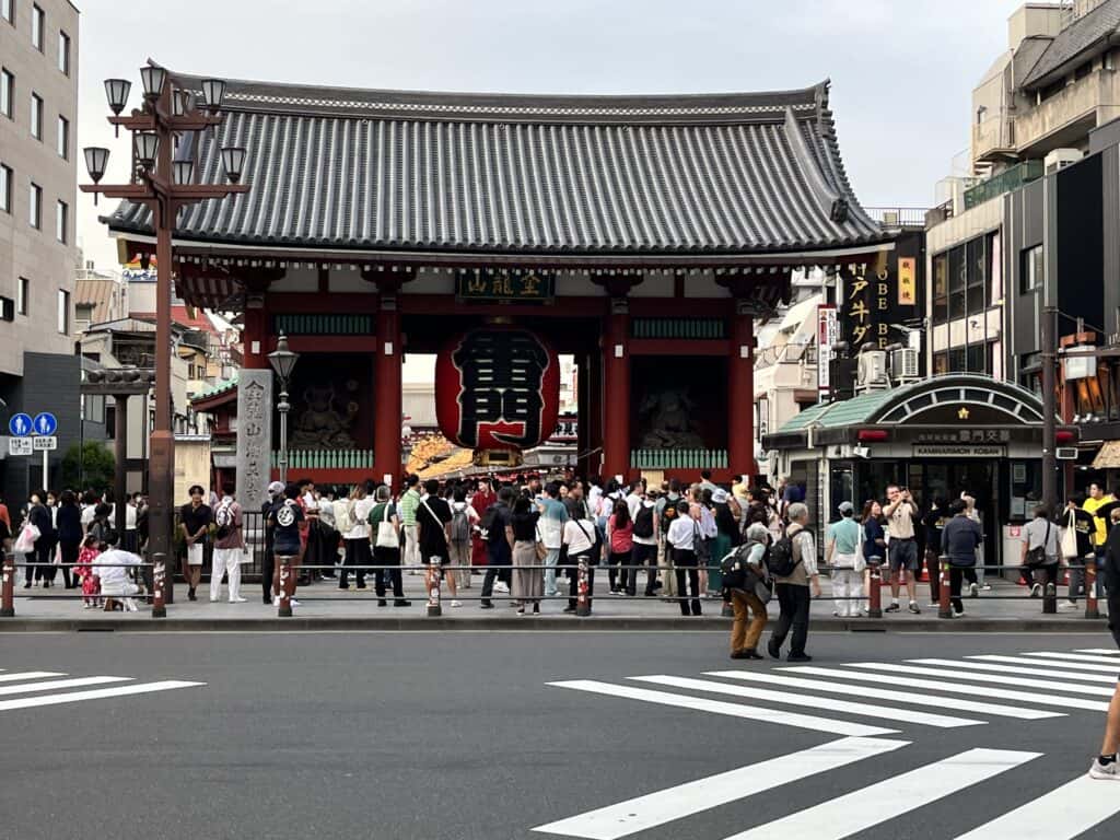 Kaminarimon Gate entrance at Senso-ji Temple in Asakusa, Tokyo, Japan, with iconic large red lantern and statues under clear blue sky