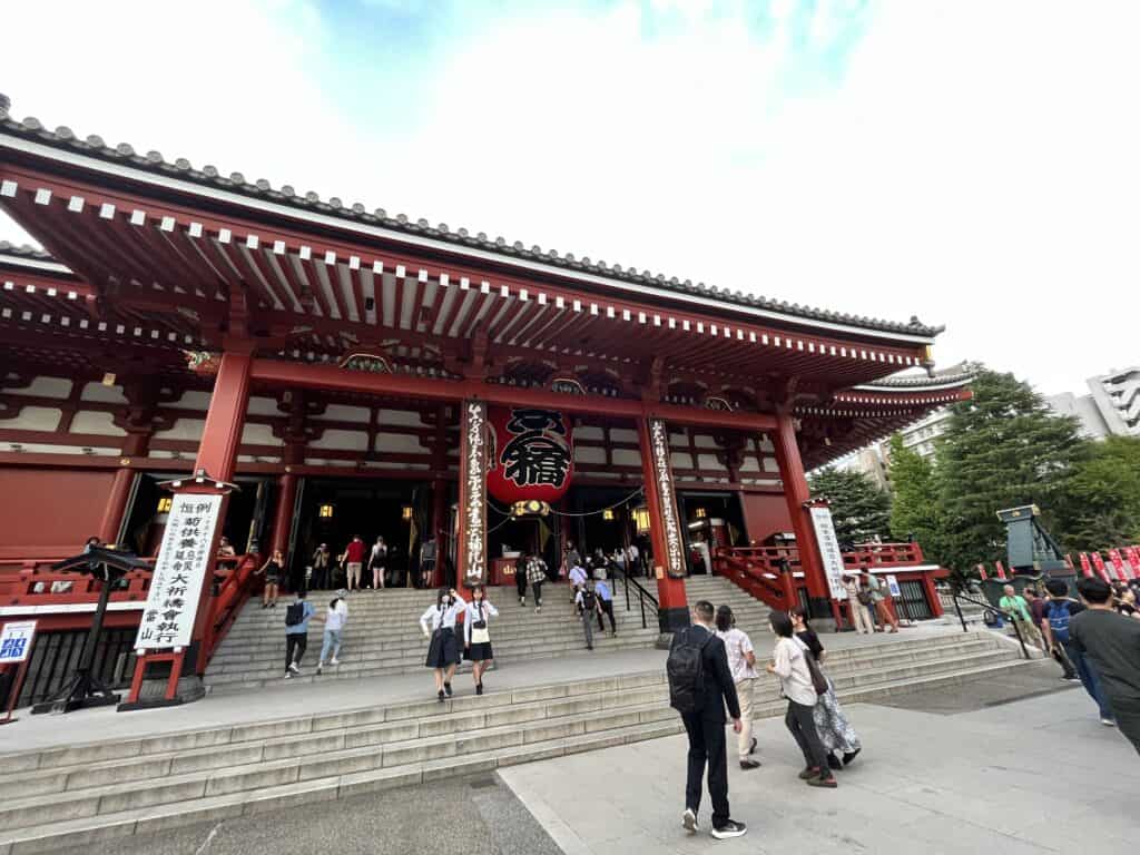 Front view of the Main Hall at Senso-ji Temple, showcasing the intricate facade and massive lantern against a clear sky in Asakusa, Tokyo.