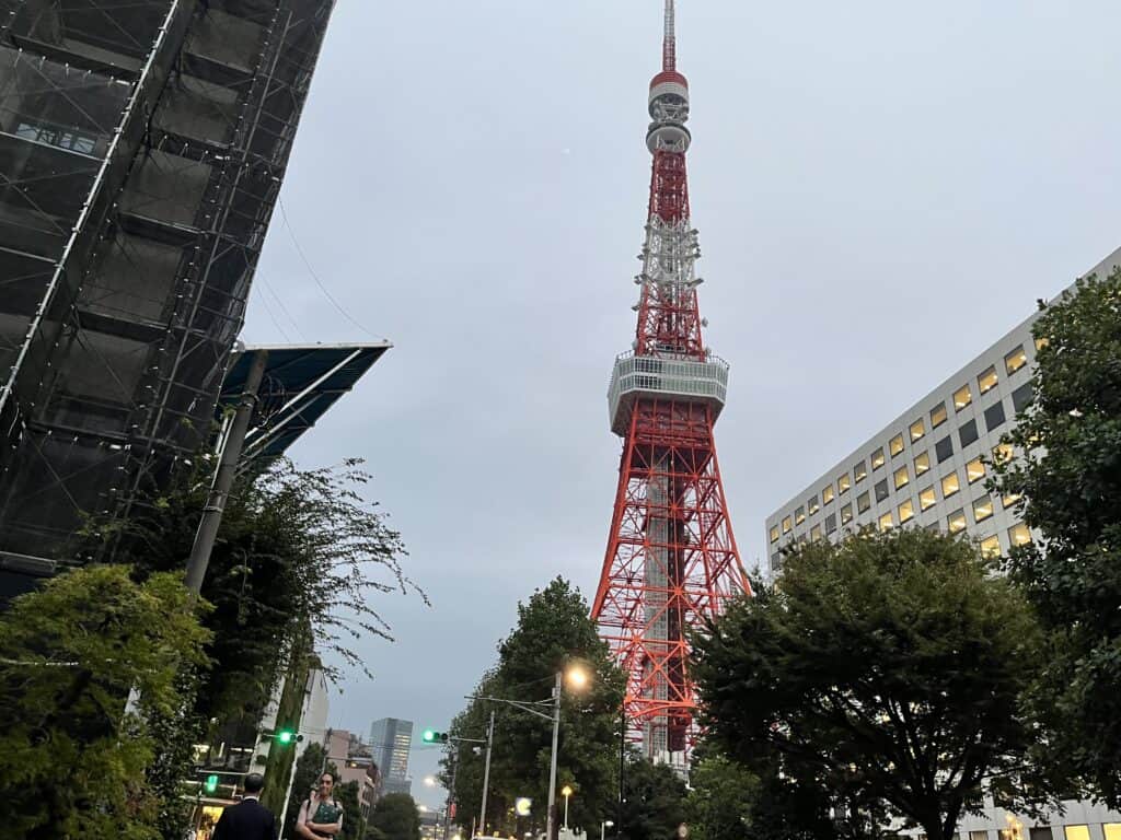 Street-level view of Tokyo Tower soaring above the city, encapsulating Japan's blend of tradition and modernity