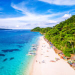 Pristine white sand and crystal-clear waters of White Beach on Boracay Island, Philippines.
