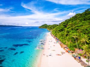 Pristine white sand and crystal-clear waters of White Beach on Boracay Island, Philippines.
