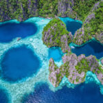 Stunning aerial view of the crystal-clear lagoons and rugged limestone cliffs of Coron, Philippines.
