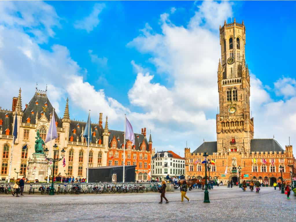 Cobblestone streets and vibrant market square in the center of Brugge, bustling with activity and historic charm