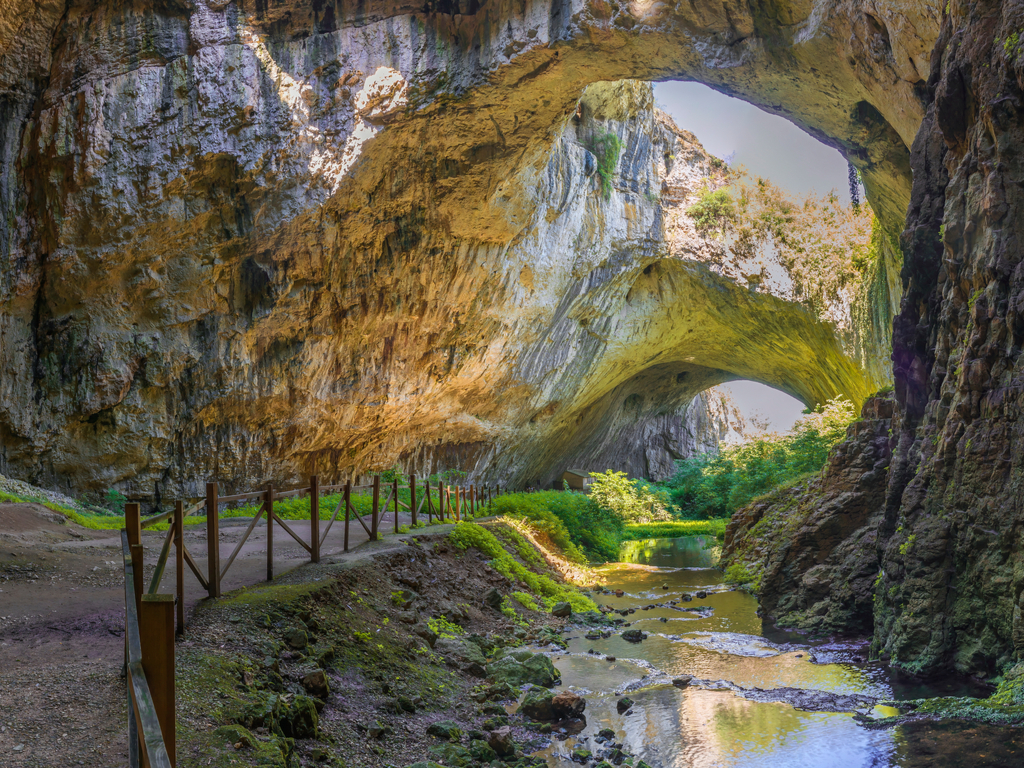 Interior of Devetashka Cave with its large caverns and distinctive skylights, creating a mystical atmosphere