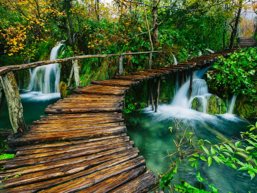 Wooden walkway winding through the scenic landscape of Plitvice Lakes National Park, offering an immersive nature experience