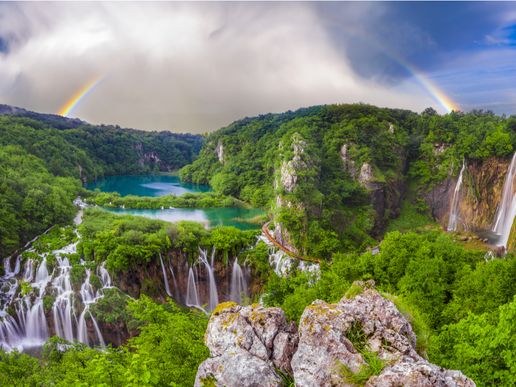 Crystal-clear turquoise waters of the Plitvice Lakes surrounded by dense forest, reflecting the serene beauty of the park