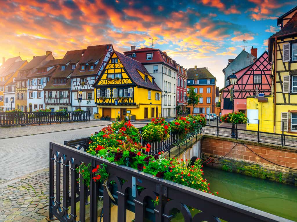 Colorful half-timbered houses lining the canals of Colmar, reflecting in the water.
