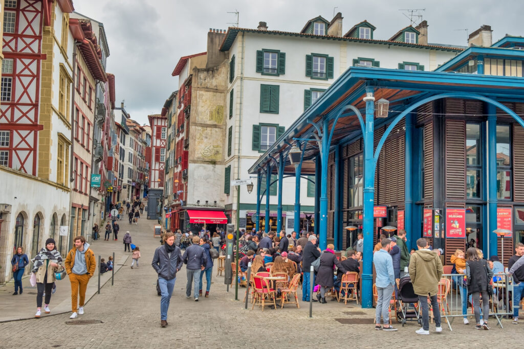 People enjoying aperitifs on the lively terraces of Bayonne market, France