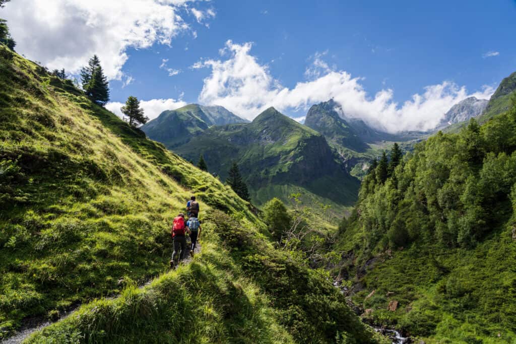 A hiker ascending the path towards Hourgade Peak in L´Ourtiga, Luchon, amidst the majestic French Pyrenees.