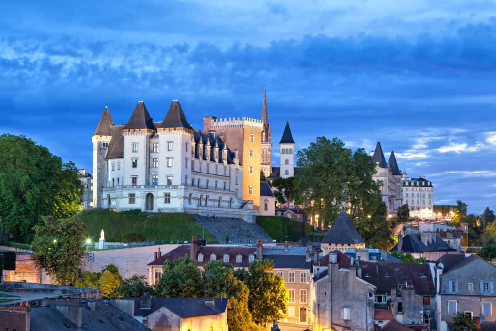 Evening view of the historic Pau Castle in the Pyrenees-Atlantiques, Aquitaine, France, under a twilight sky.