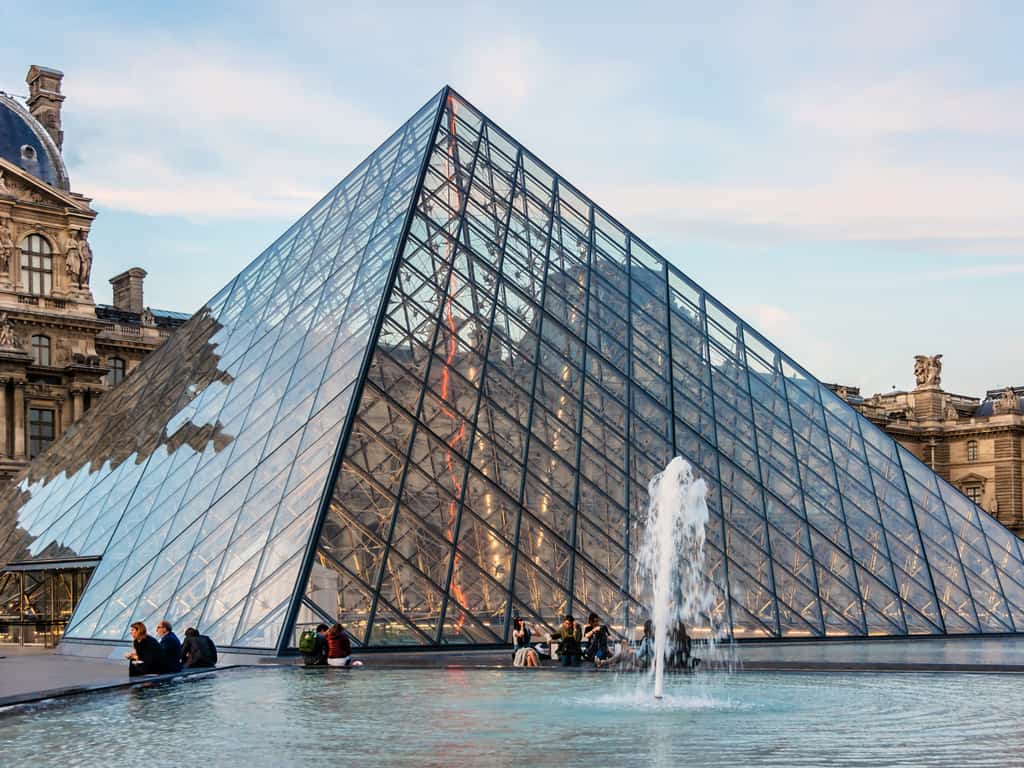 The iconic glass pyramid of the Louvre Museum in Paris, a blend of modern and historic architecture.