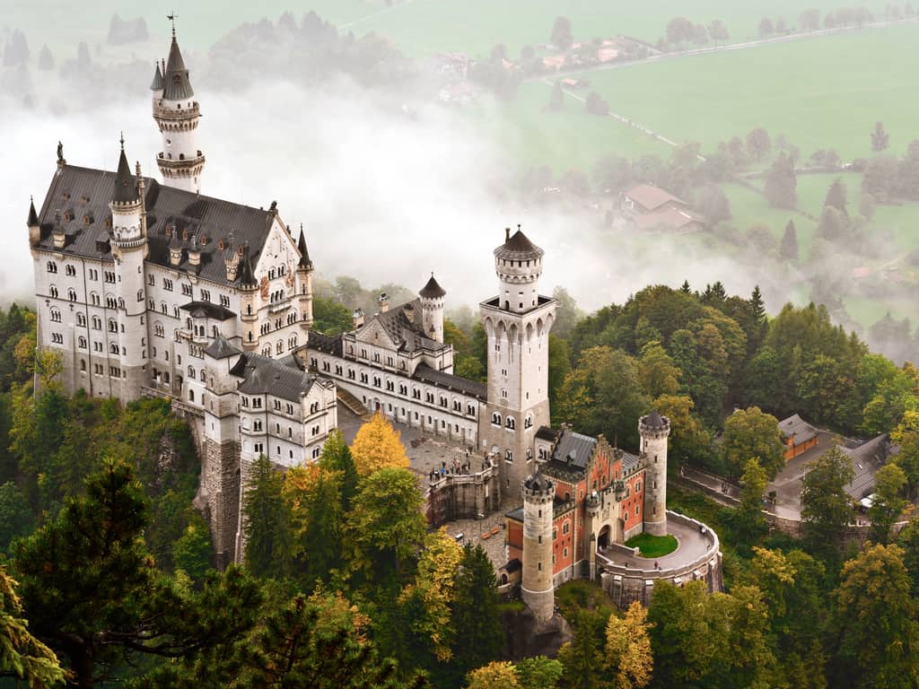 Stunning view of Neuschwanstein Castle shrouded in mist, creating a mystical atmosphere.