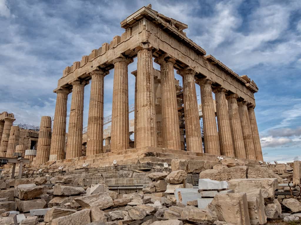 The Parthenon temple standing majestically on the Acropolis hill under a clear blue sky in Athens.