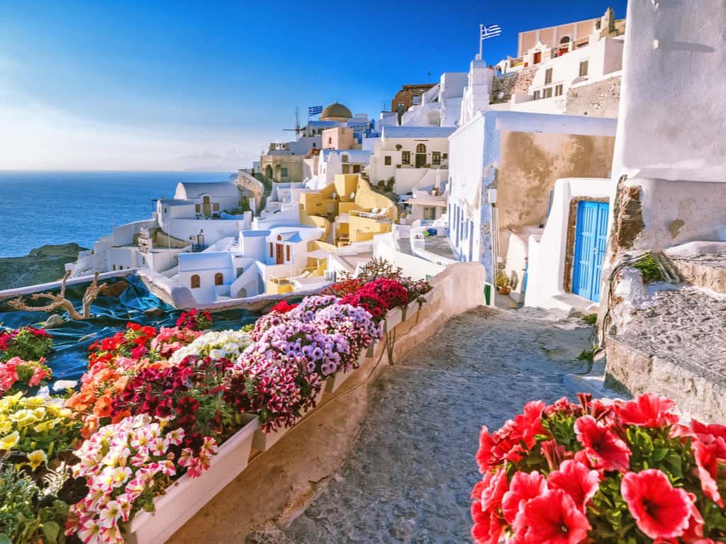 Narrow, winding streets of Oia with charming boutiques and cafes, inviting exploration.