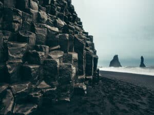 The iconic Reynisdrangar sea stacks seen from the Black Beach of Vik, creating a dramatic and picturesque scene