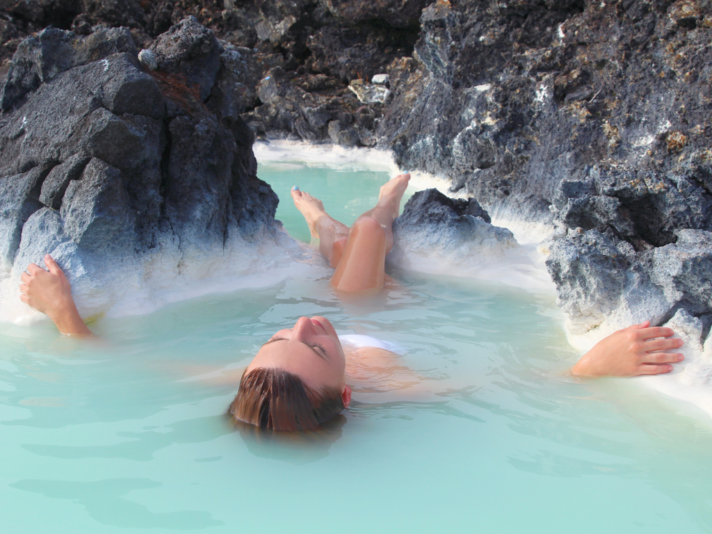 People relaxing in the steamy, milky-blue waters of the Blue Lagoon in Iceland.