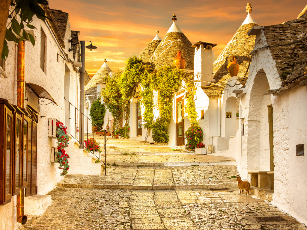 Sunset casting a warm glow over the trulli of Alberobello, creating a romantic atmosphere.