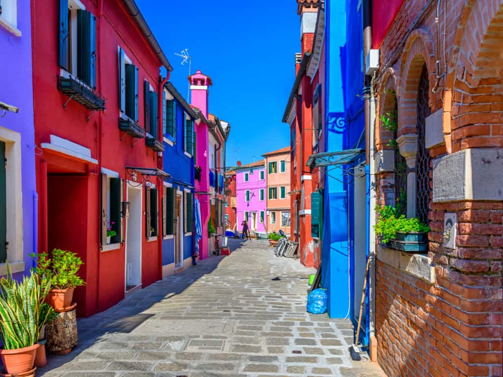 Narrow, charming streets of Burano, inviting visitors to explore the island's hidden corners and vibrant architecture