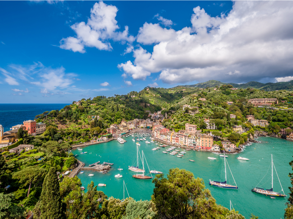 Colorful houses and luxury yachts lining the harbor of Portofino, Italy.