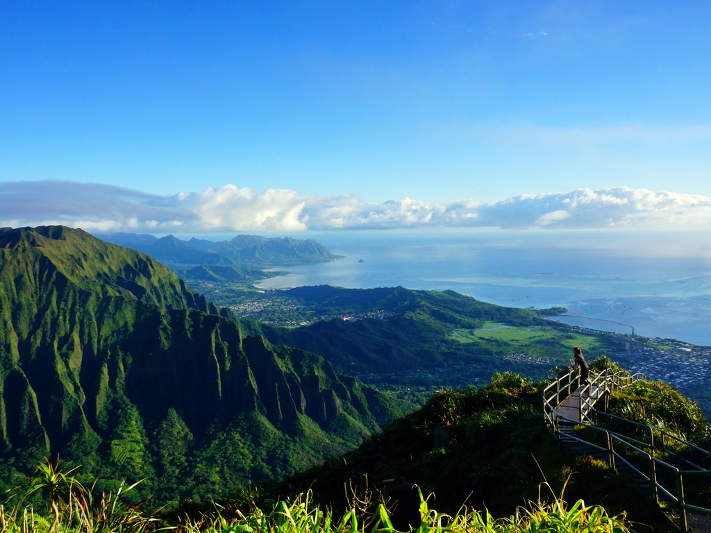 Breathtaking view from the top of the Haiku Stairs in Hawaii, overlooking lush green valleys.