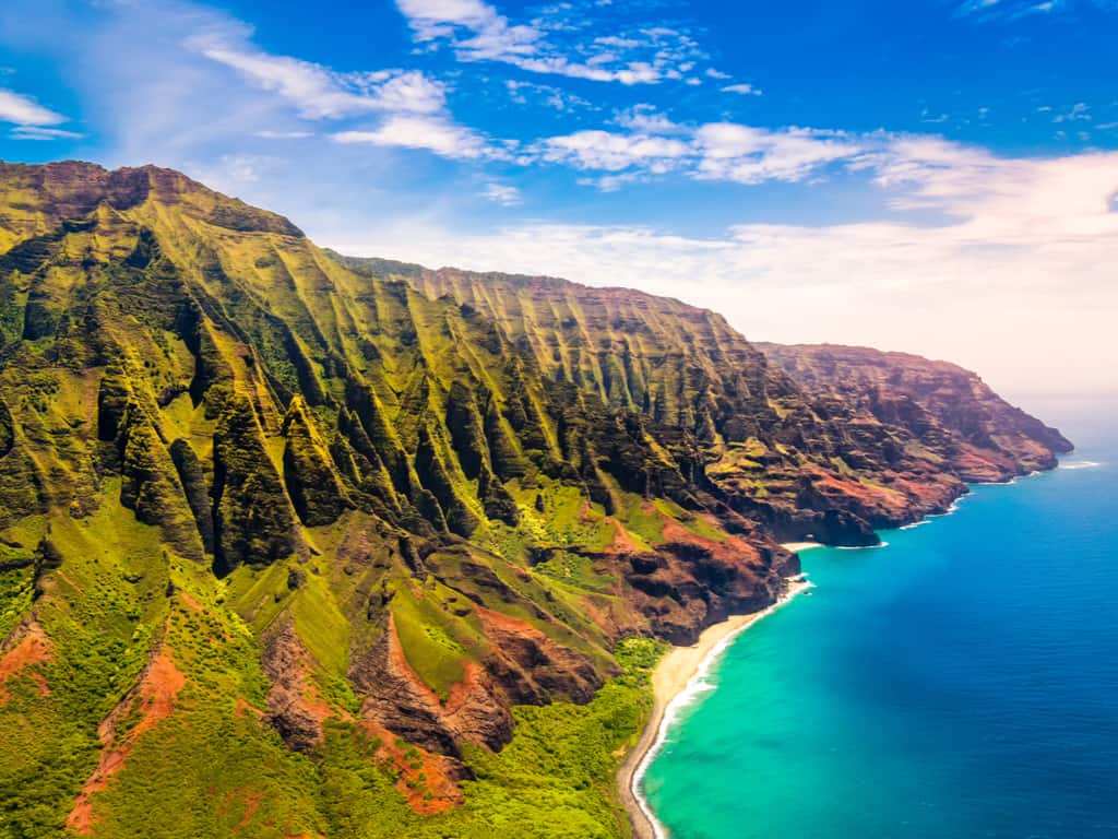 Aerial view of the Na Pali Coast in Kauai, showcasing its dramatic cliffs and turquoise waters.