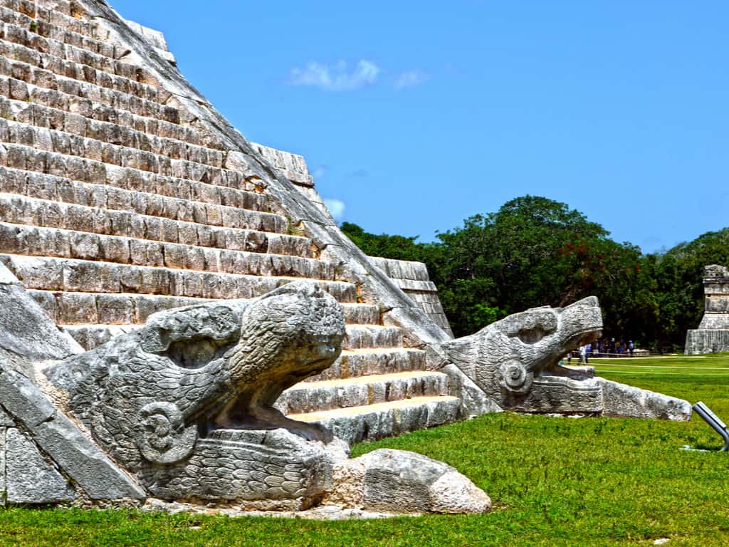 Intricate stone carvings depicting Mayan deities and symbols at Chichen Itza.