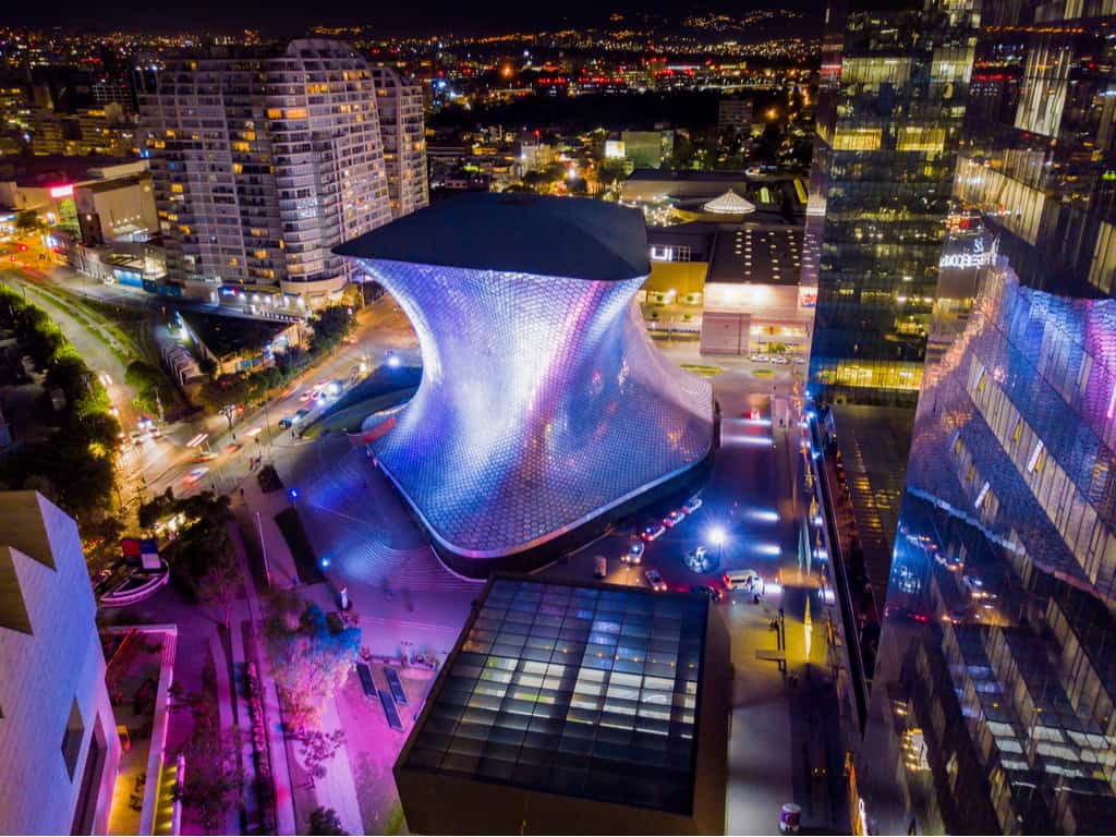 The Soumaya Museum lit up at night, showcasing its futuristic design and becoming a beacon of culture in Mexico City