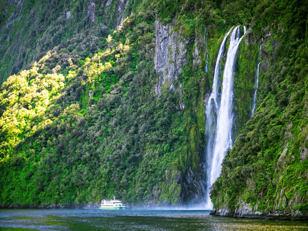Majestic view of Milford Sound with towering cliffs and cascading waterfalls in New Zealand.