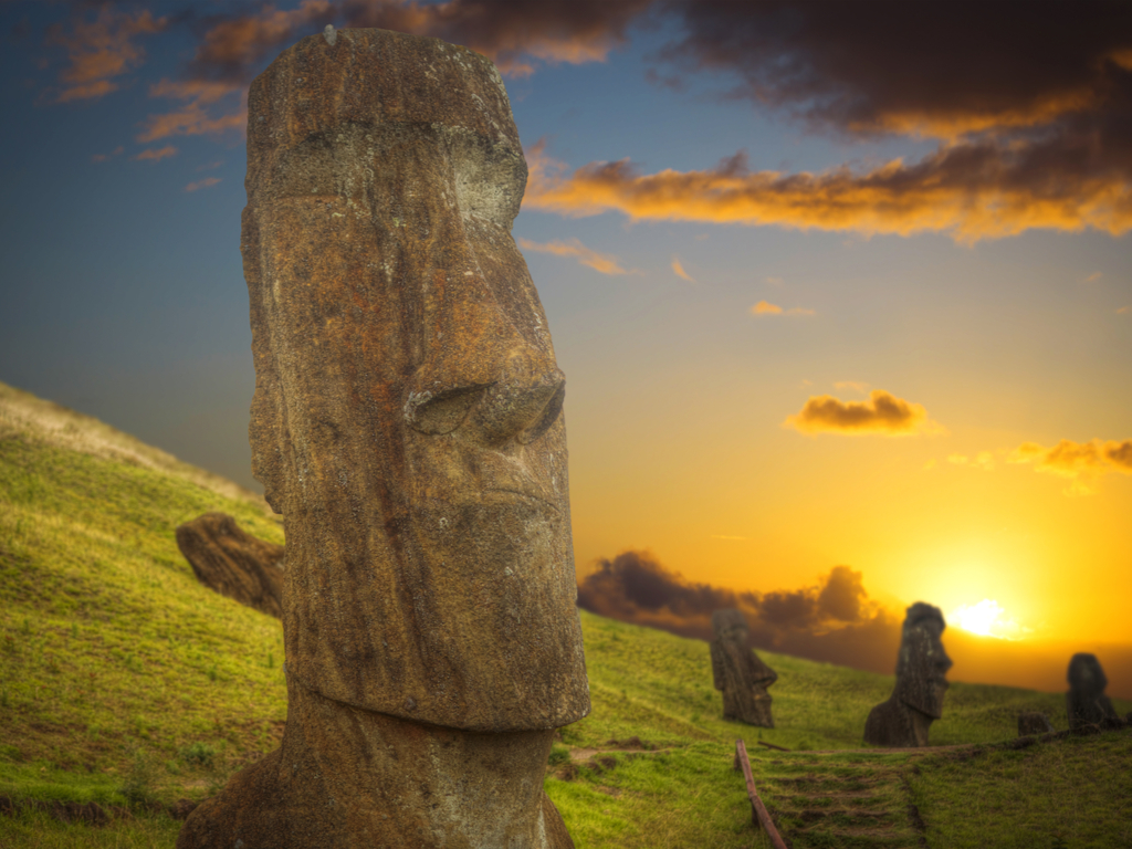 "Iconic moai statues standing against a backdrop of a clear blue sky on Easter Island, a symbol of the island's mysterious past